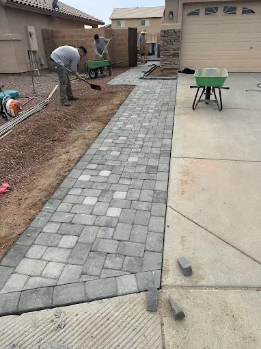 Paver walkway installation beside a residence