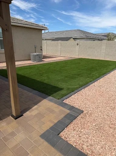 Artificial turf, pavers, and decorative rock in a Buckeye-area yard